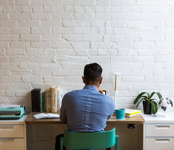 Un homme devant son bureau sur un ordinateur
