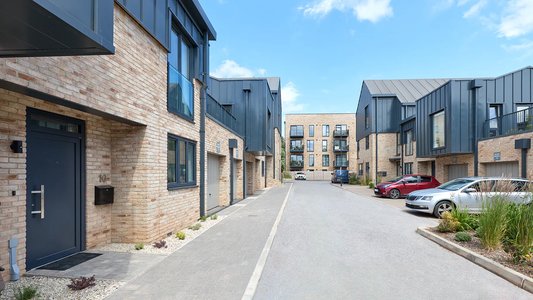Completed homes in East Court, the occupied phase of St Leonards Quarter, with the apartment building visible at the end of the street.