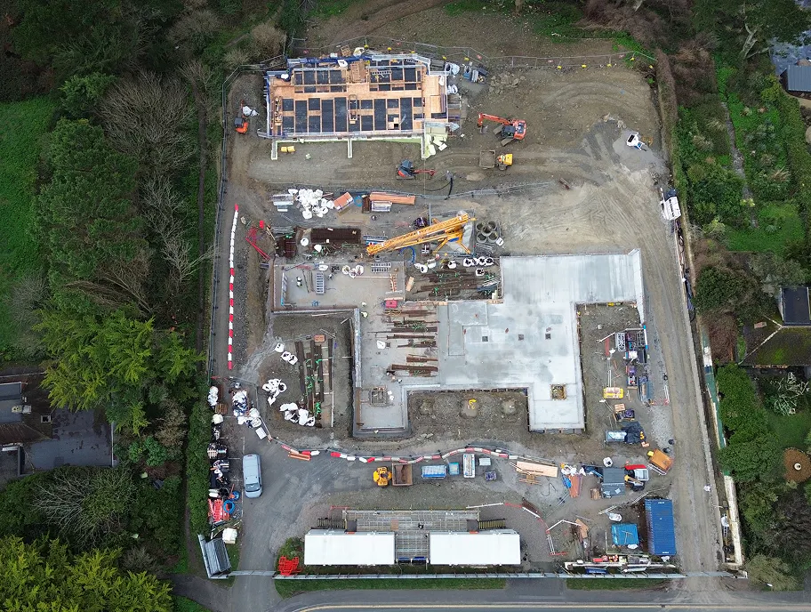 Concrete screeded and levelled across both residential blocks, with rebar grids and column starter bars ready to receive the structure above.