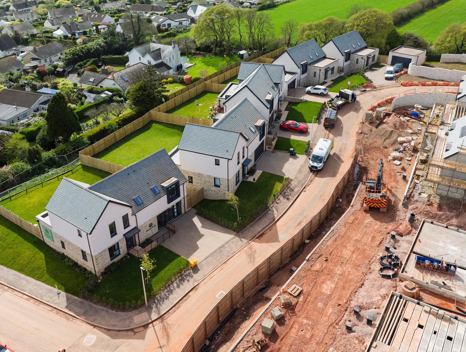Plots 1 to 5, looking ready for handover, while construction continues on the other side of the road.