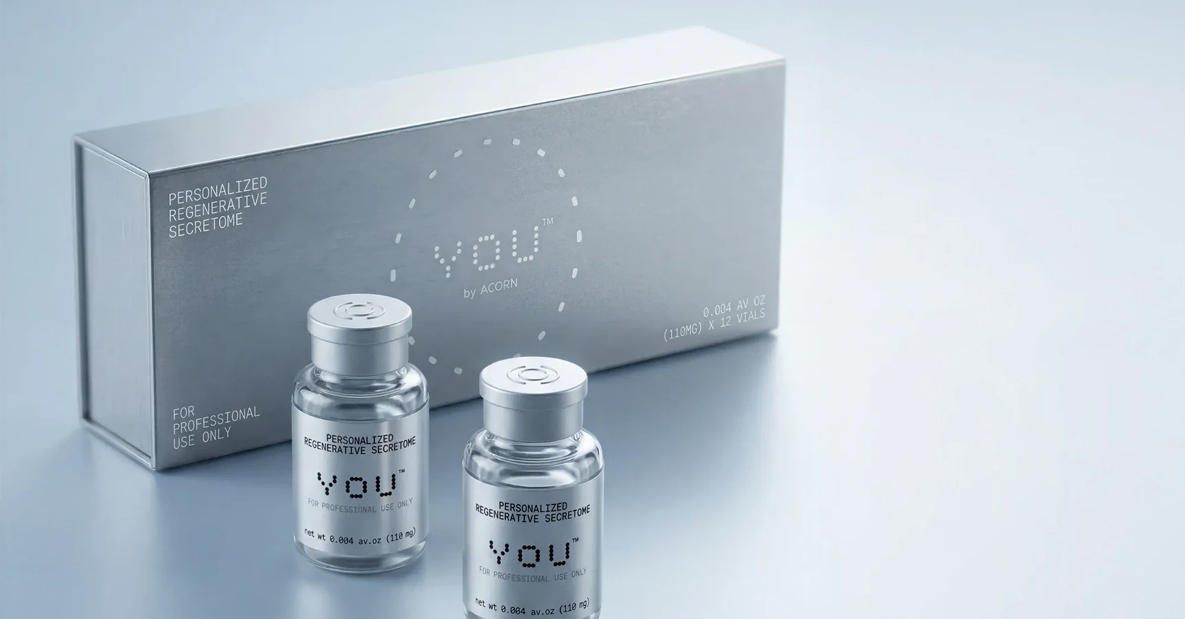 Two bottles of regenerative secretome serum beside a decorative box, showcasing an elegant packaging design.