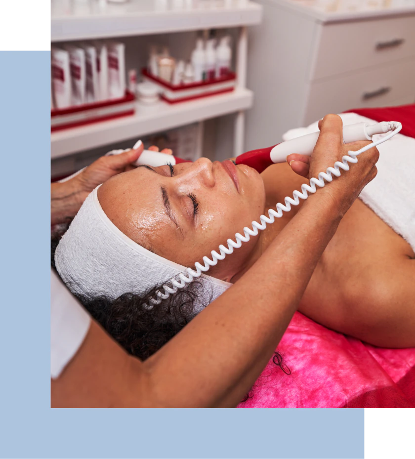 A woman undergoes a facial treatment in a peaceful spa setting, featuring soft lighting and a calming atmosphere.