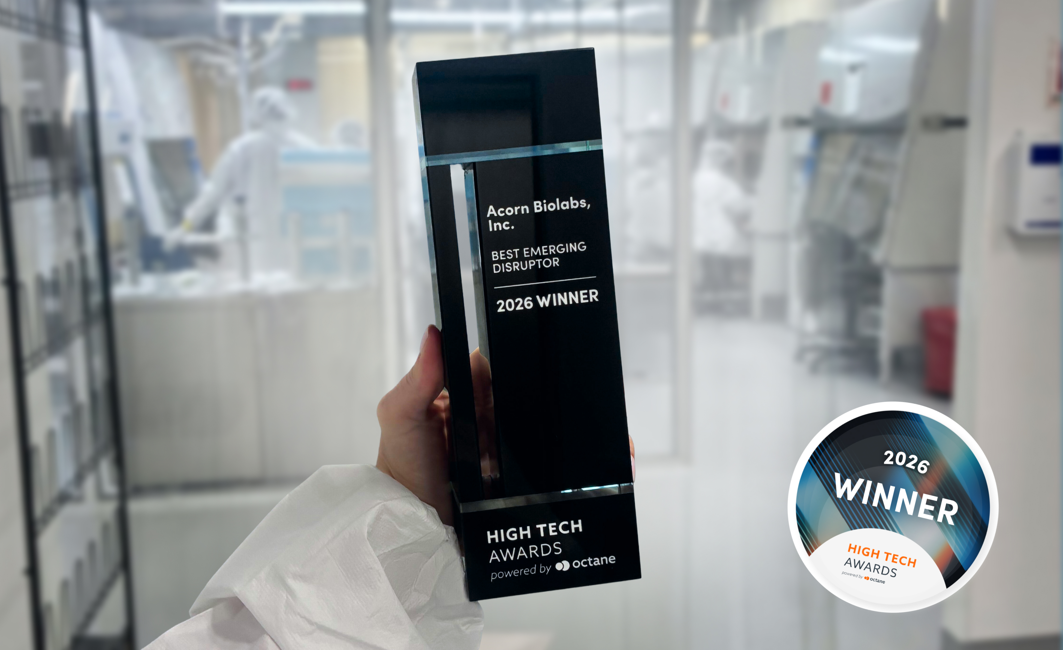 In a laboratory, an individual proudly displays a black and white award for the Best Emerging Disruptor.
