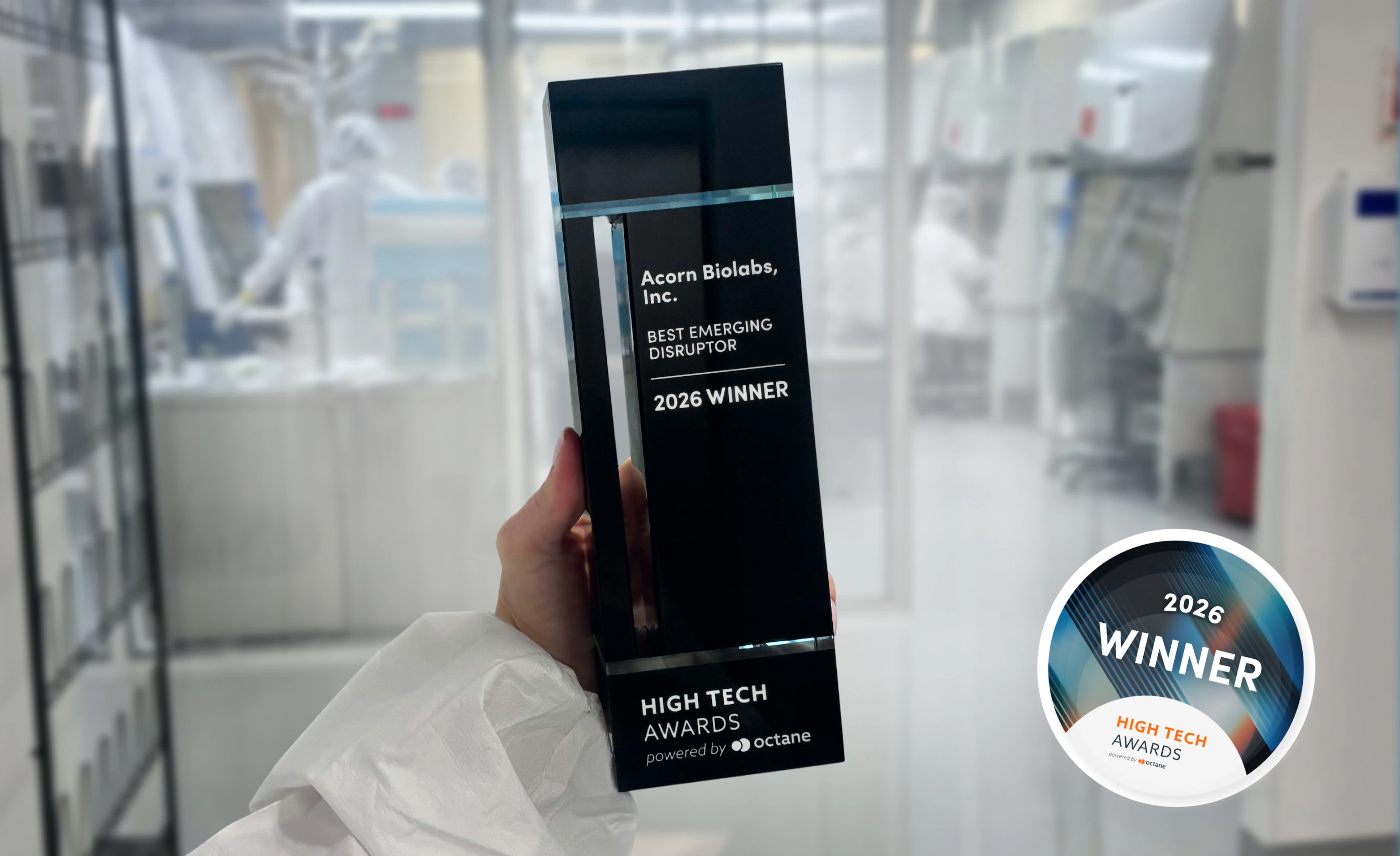 In a laboratory, an individual proudly displays a black and white award for the Best Emerging Disruptor.