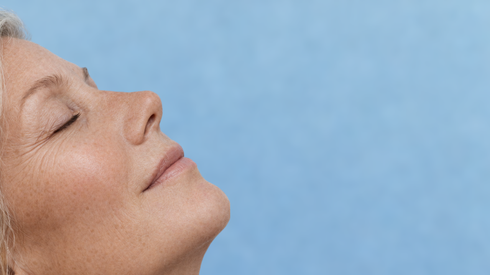 A woman with her eyes shut and head held high, reflecting a moment of serenity and self-reflection.