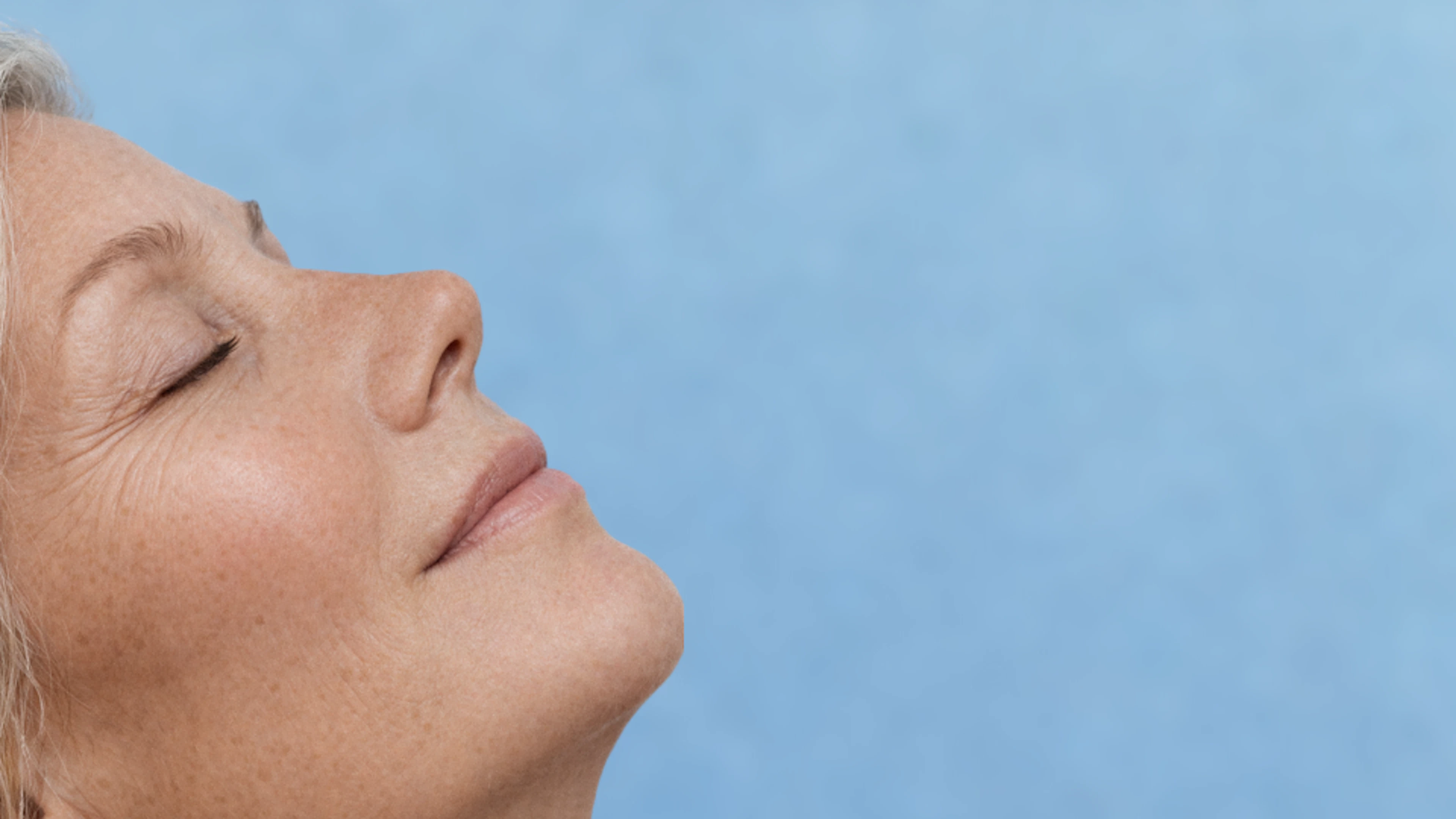 A woman with her eyes shut and head held high, reflecting a moment of serenity and self-reflection.