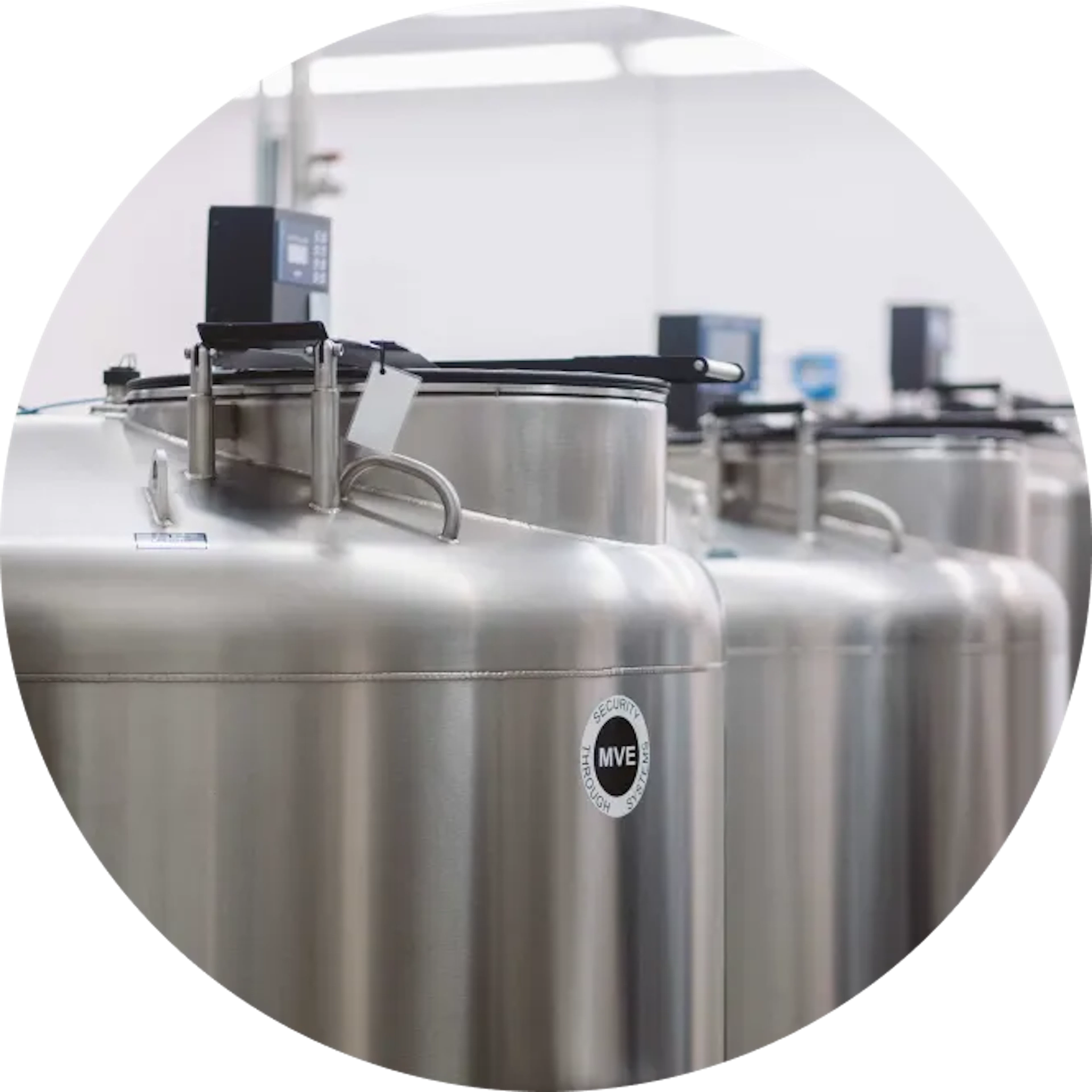 A row of cryogenic storage tanks with digital monitors, used for preserving biological samples in a laboratory.