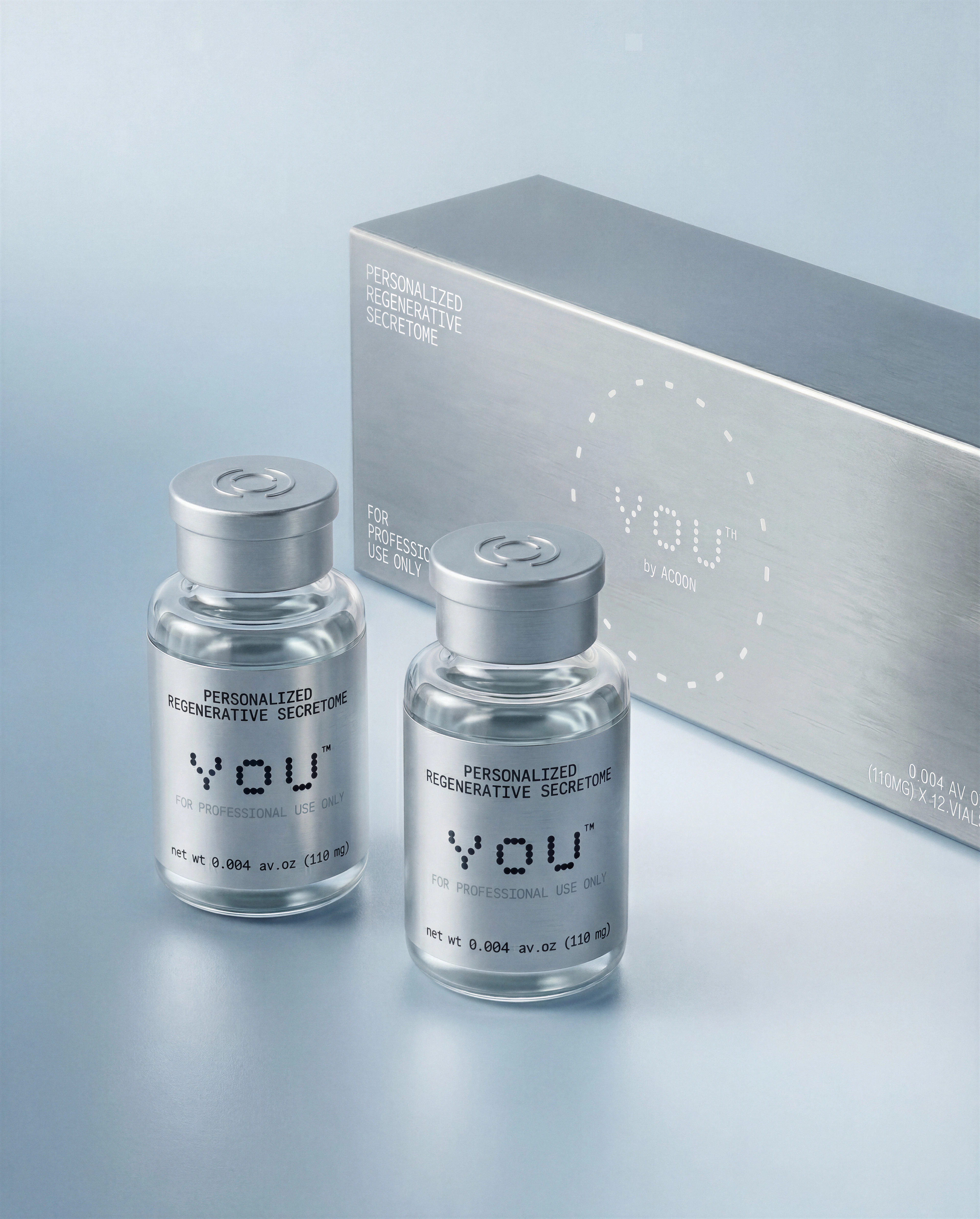 Two bottles of regenerative secretome serum beside a decorative box, showcasing an elegant packaging design.
