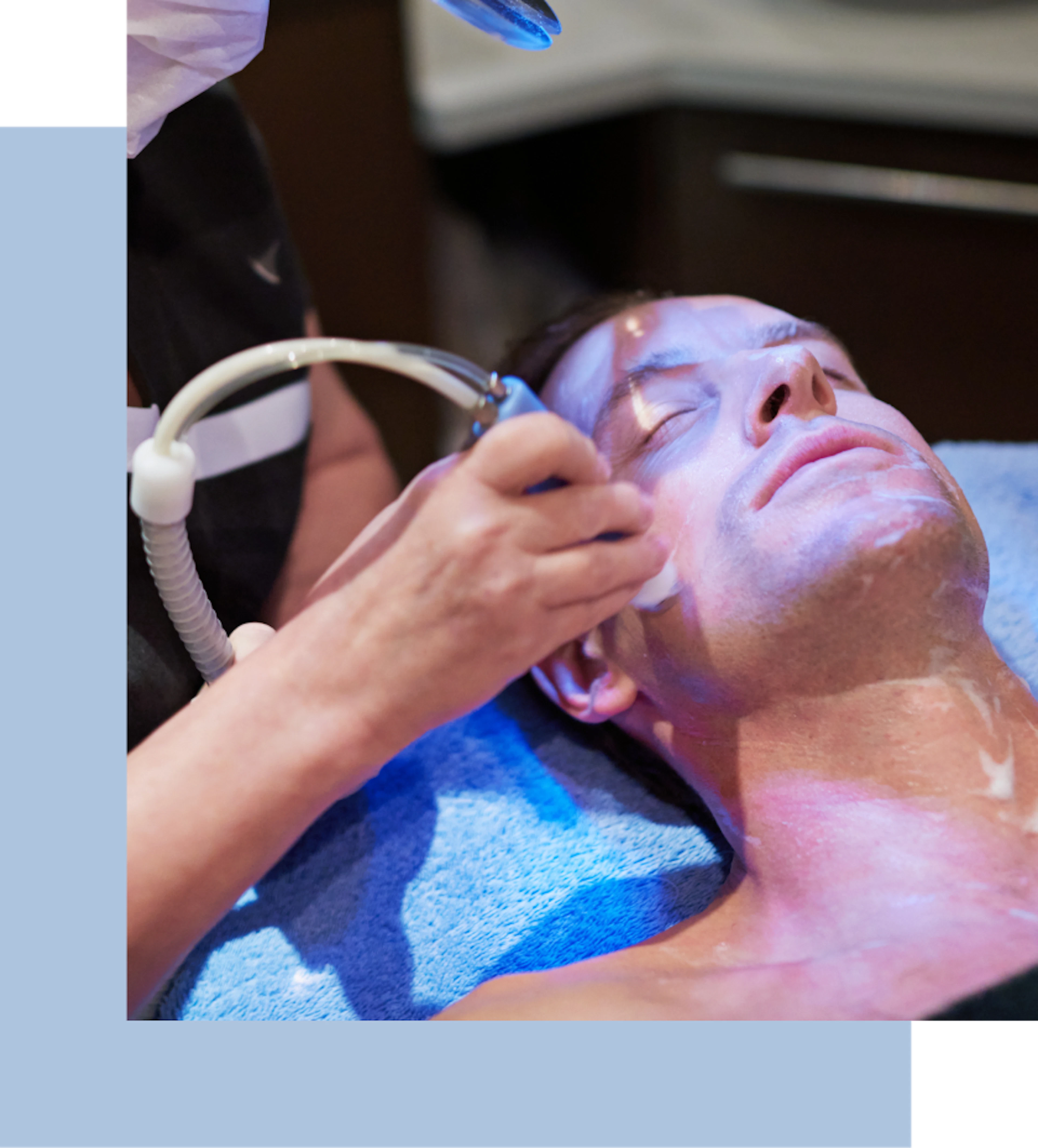 A man relaxes in a spa while receiving a facial treatment, surrounded by calming decor and soft lighting.