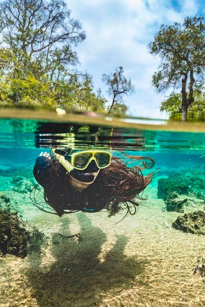 Pessoa fazendo flutuação em água cristalina