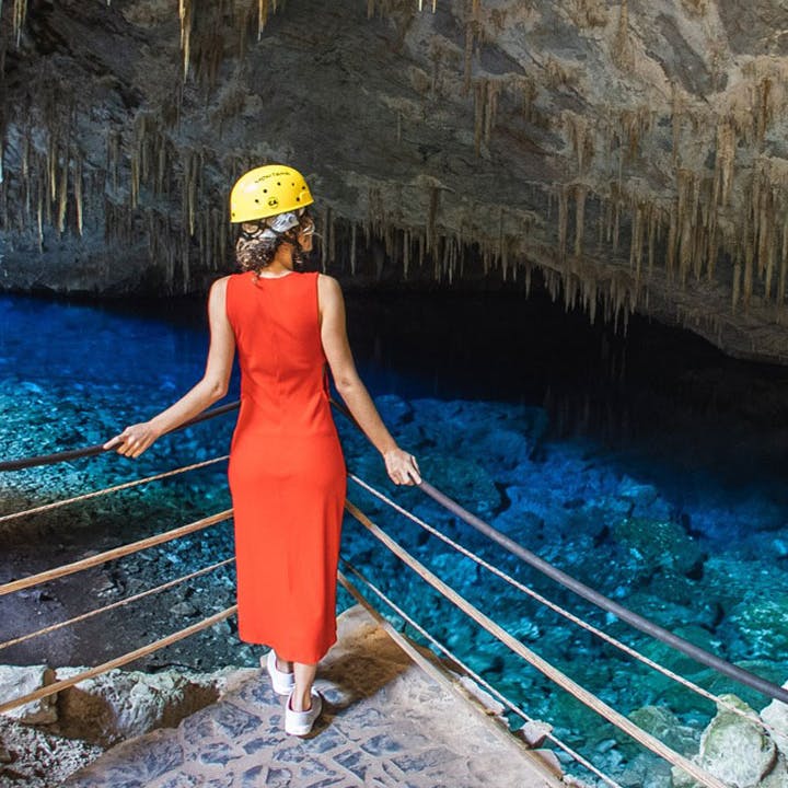 mulher admirando gruta com água azul