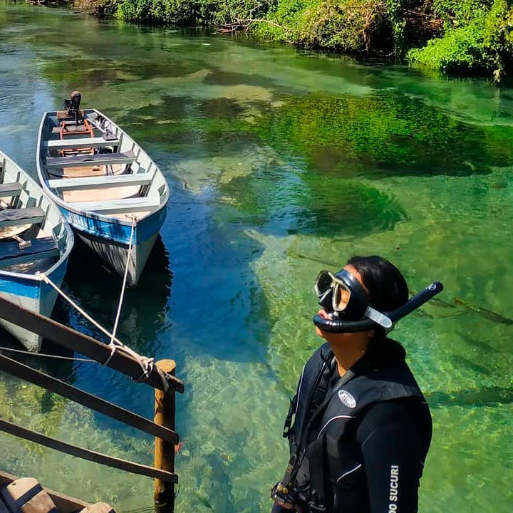 pessoa com mascara de mergulho em rio de águas cristalinas
