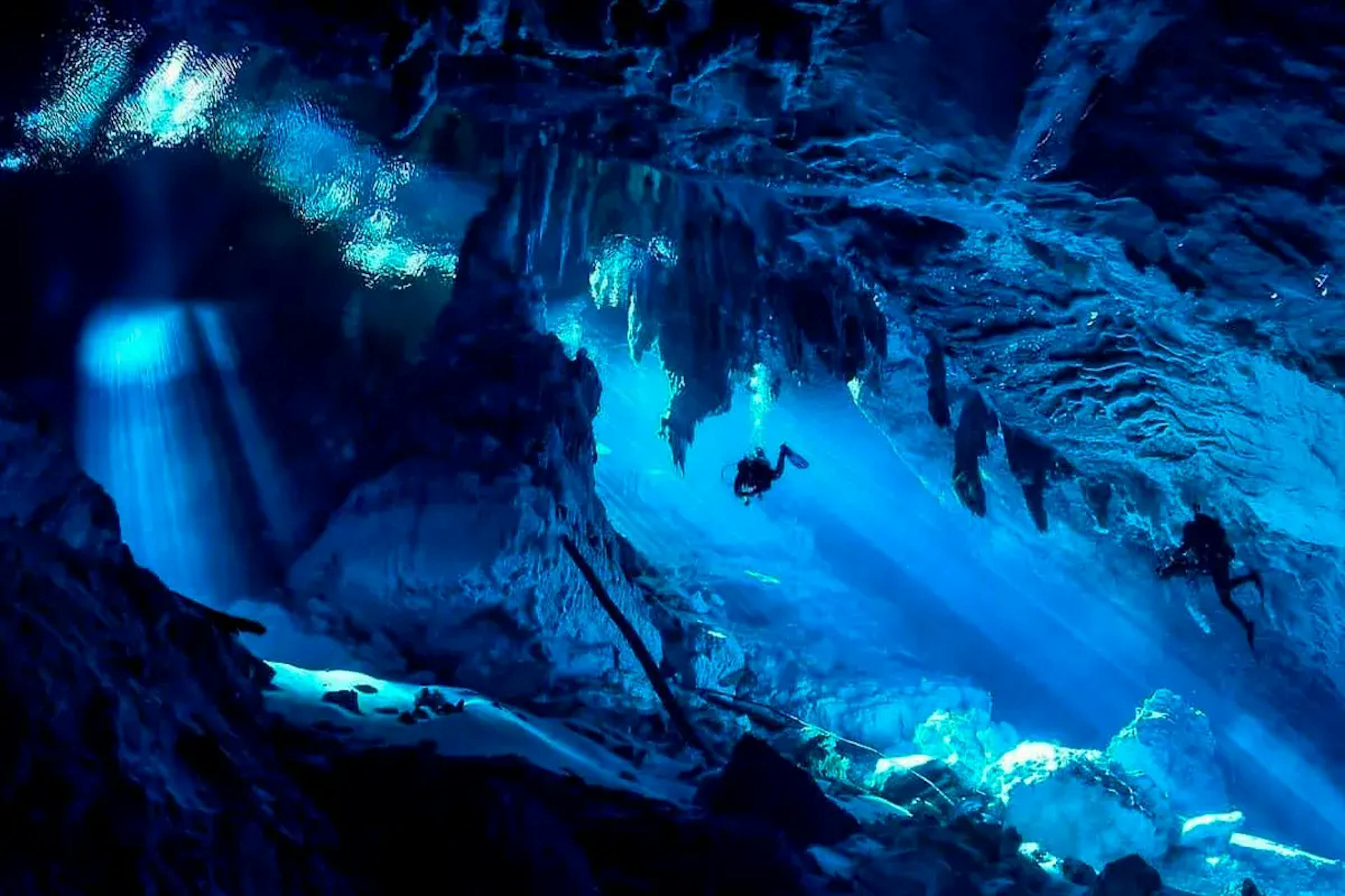 Pesquisadores mergulhando no Lago sob efeito azul intenso