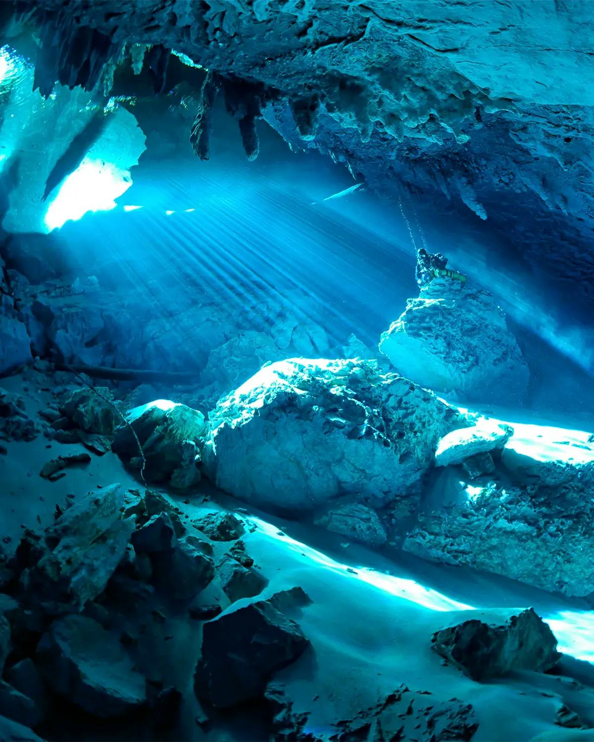 Rochas subterrâneas sob efeito intensamente azul proporcionado pela luz solar que penetra na Gruta do Lago Azul em Bonito MS