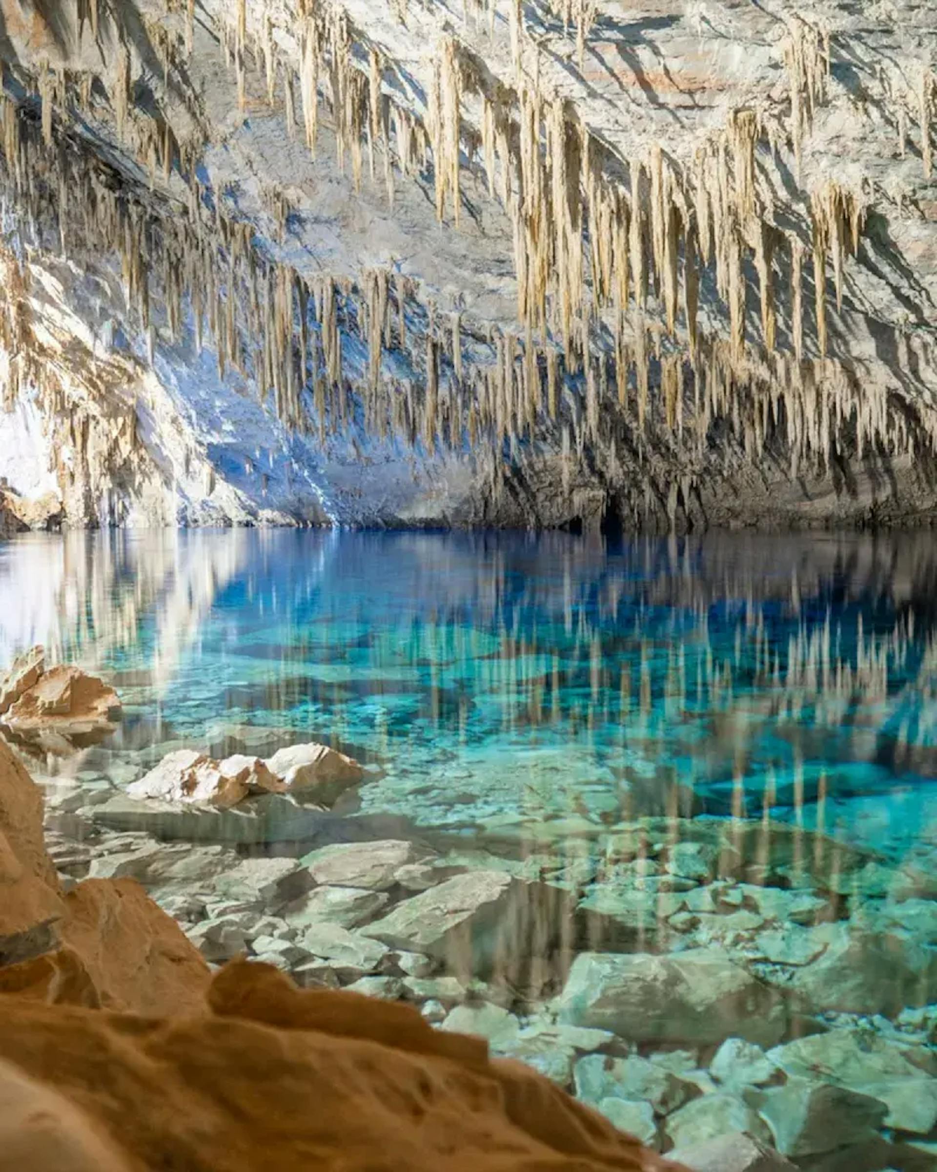 Rochas submersas visíveis através da cristalinidade aquática da Gruta do Lago Azul
