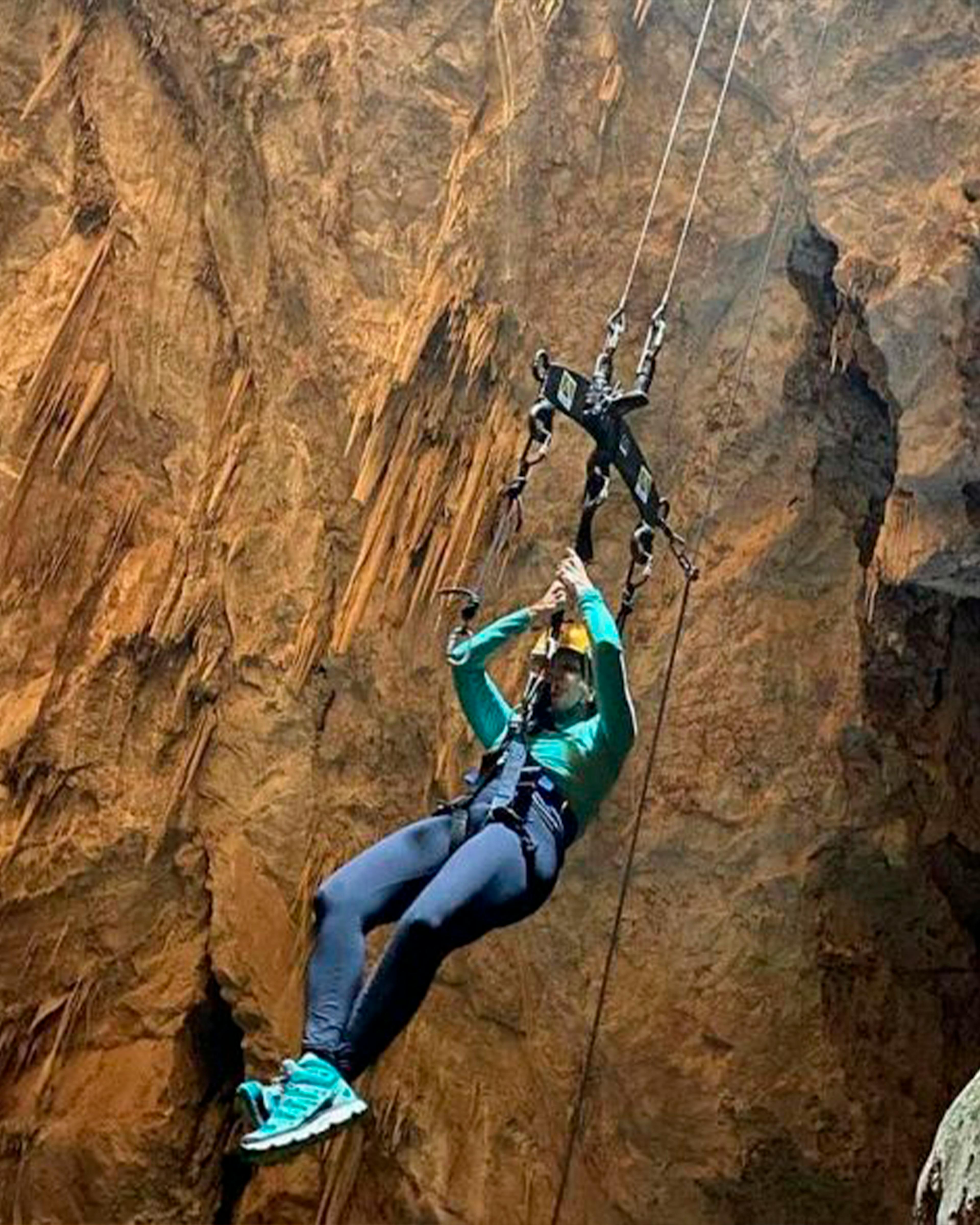 Turista descendo rapel elétrico para adentrar na caverna Abismo Anhumas em Bonito MS