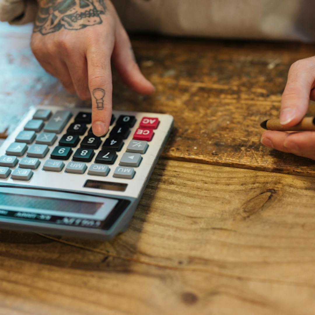 Man using a calculator to work out his driving instructor salary