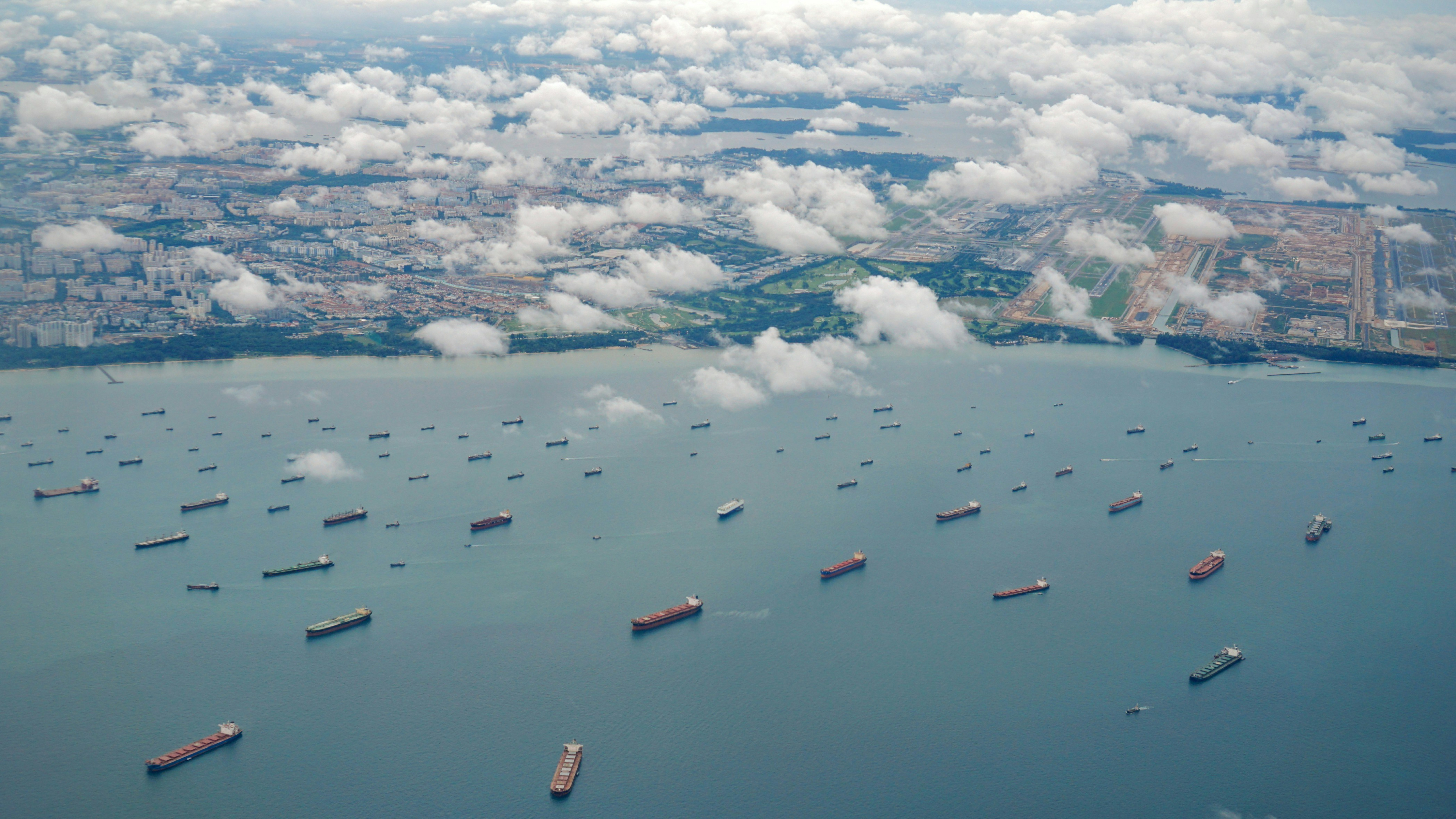 Fleet of container ships heading toward harbor, symbolizing international supply chains and wholesale import of electronic parts and components.