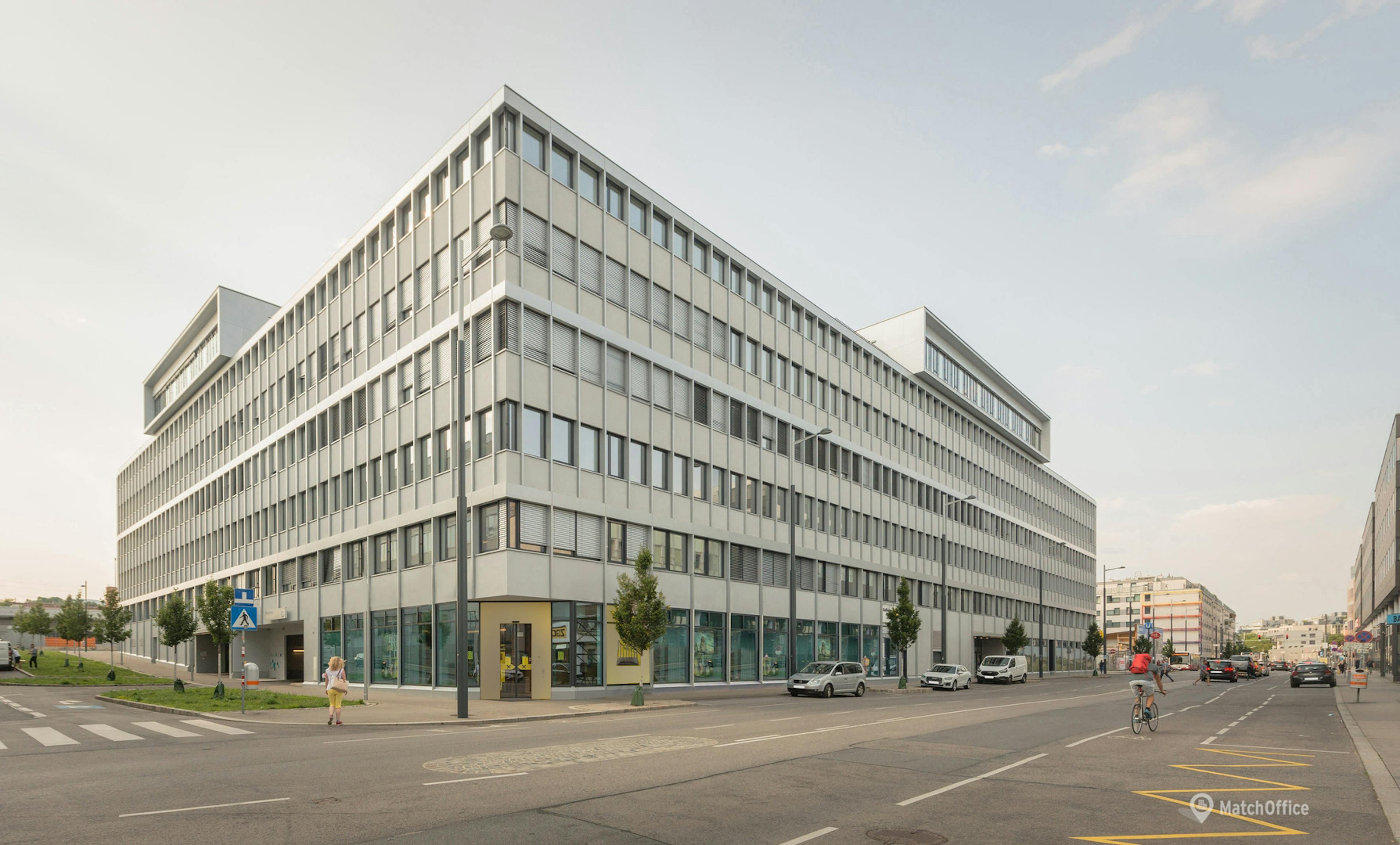 Modern office building with street in the foreground, representing corporate presence, accessibility, and business operations in the electronics wholesale sector.