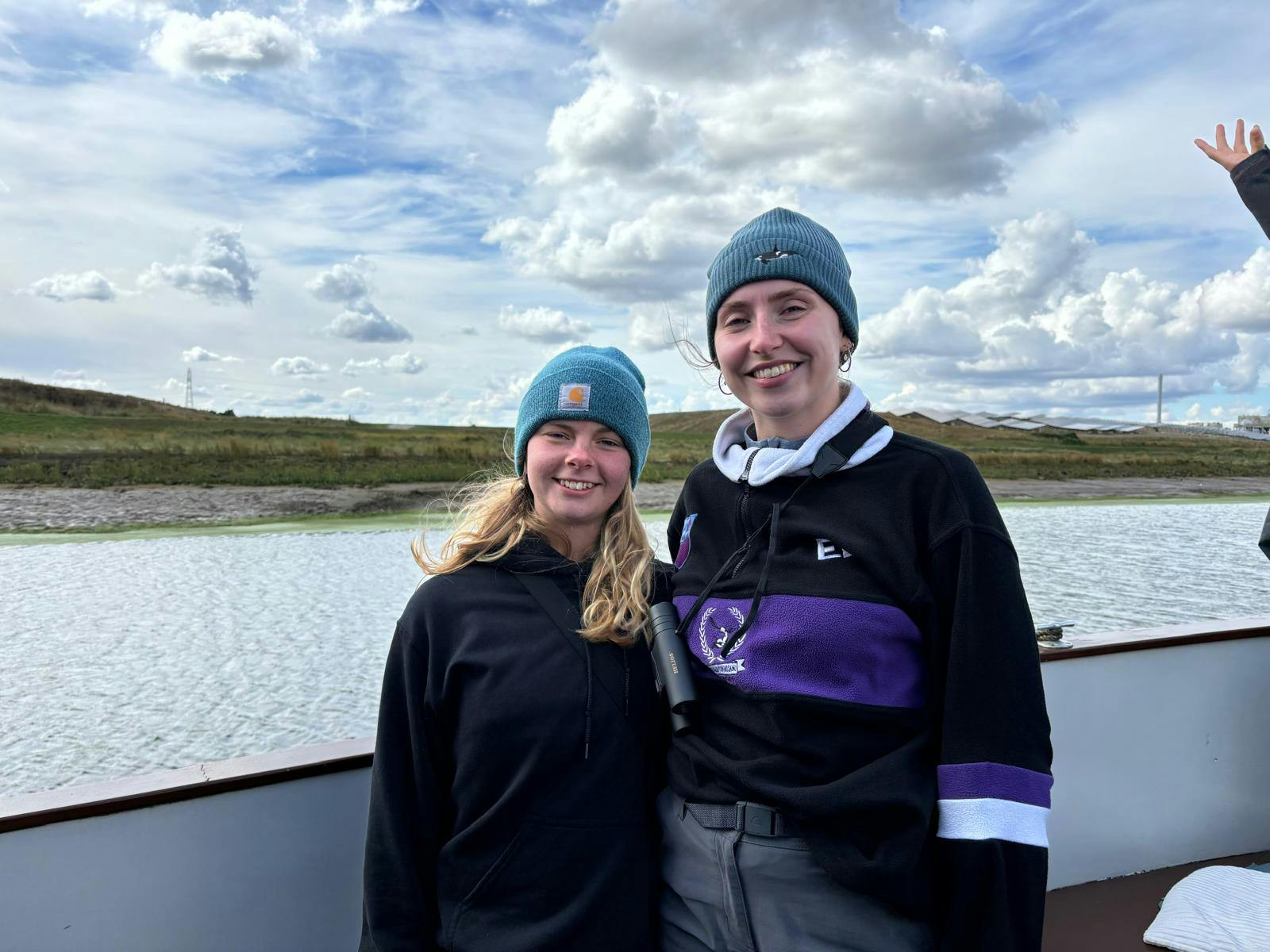 Two people on a boat smiling at the camera 