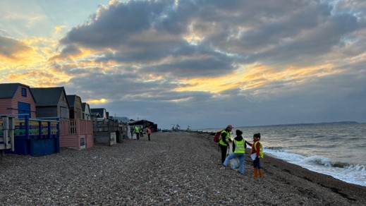 litter pickers walking along shoreline