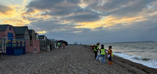 litter pickers walking along shoreline