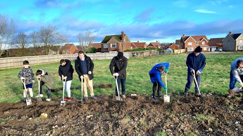 A group of people digging into the ground