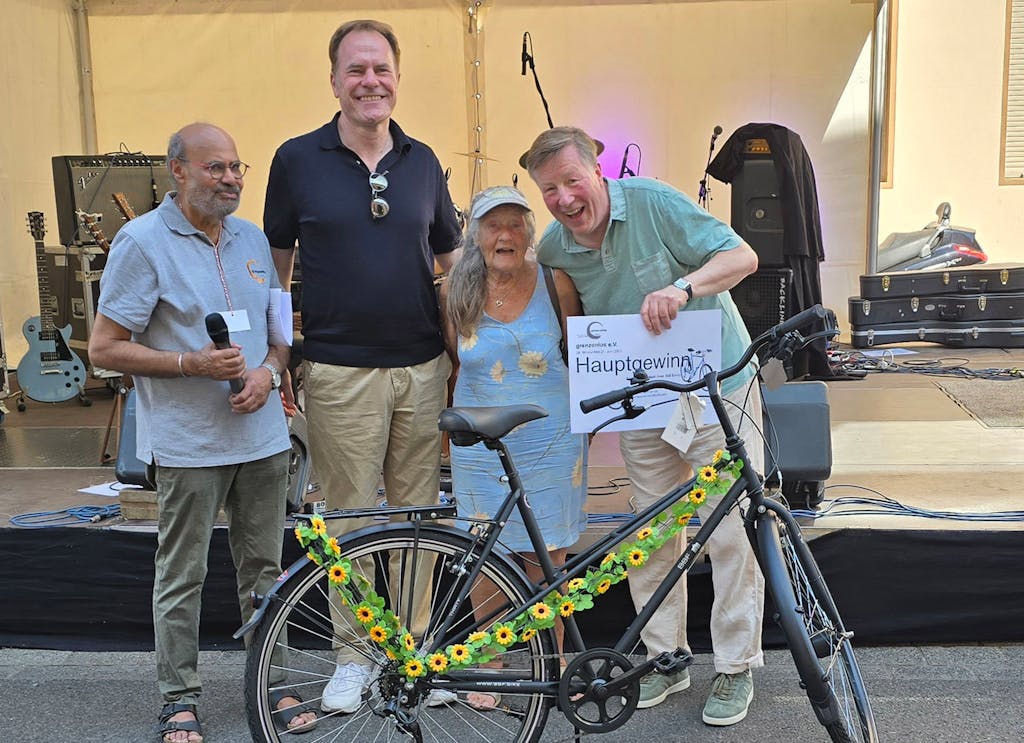 Übergabe des Tombola-Hauptpreises, einem Fahrrad (von links nach rechts): Davinder Singh, Vorstandsvorsitzender des „grenzenlos e.V.“, Dr. Stephan Keller, Oberbürgermeister der Landeshauptstadt Düsseldorf, die Gewinnerin Johanna G. und Thomas Glodek, Leiter Öffentlichkeitsarbeit Aengevelt Immobilien.