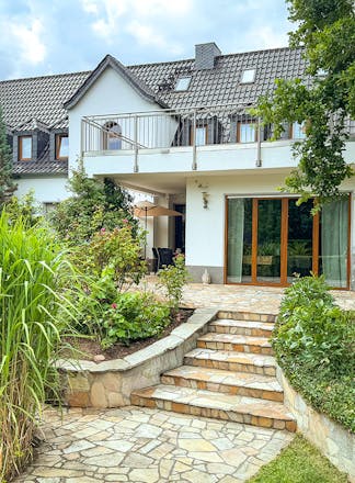 Blick aus dem Garten auf eine weiße Stadtvilla