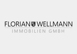 Das Florian Wellmann Immobilien Logo in Graustufen aus hellgrauem Hintergrund