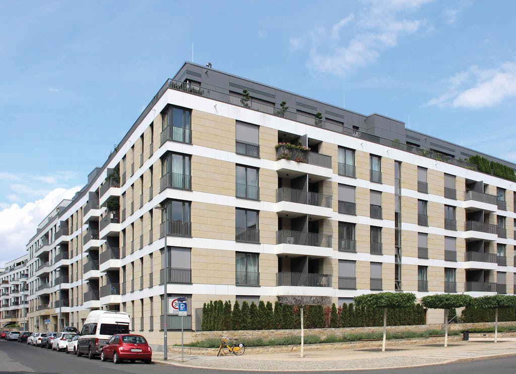 Außenansicht eines modernen Wohngebäudekomplexes mit beiger Fassade und Balkonen