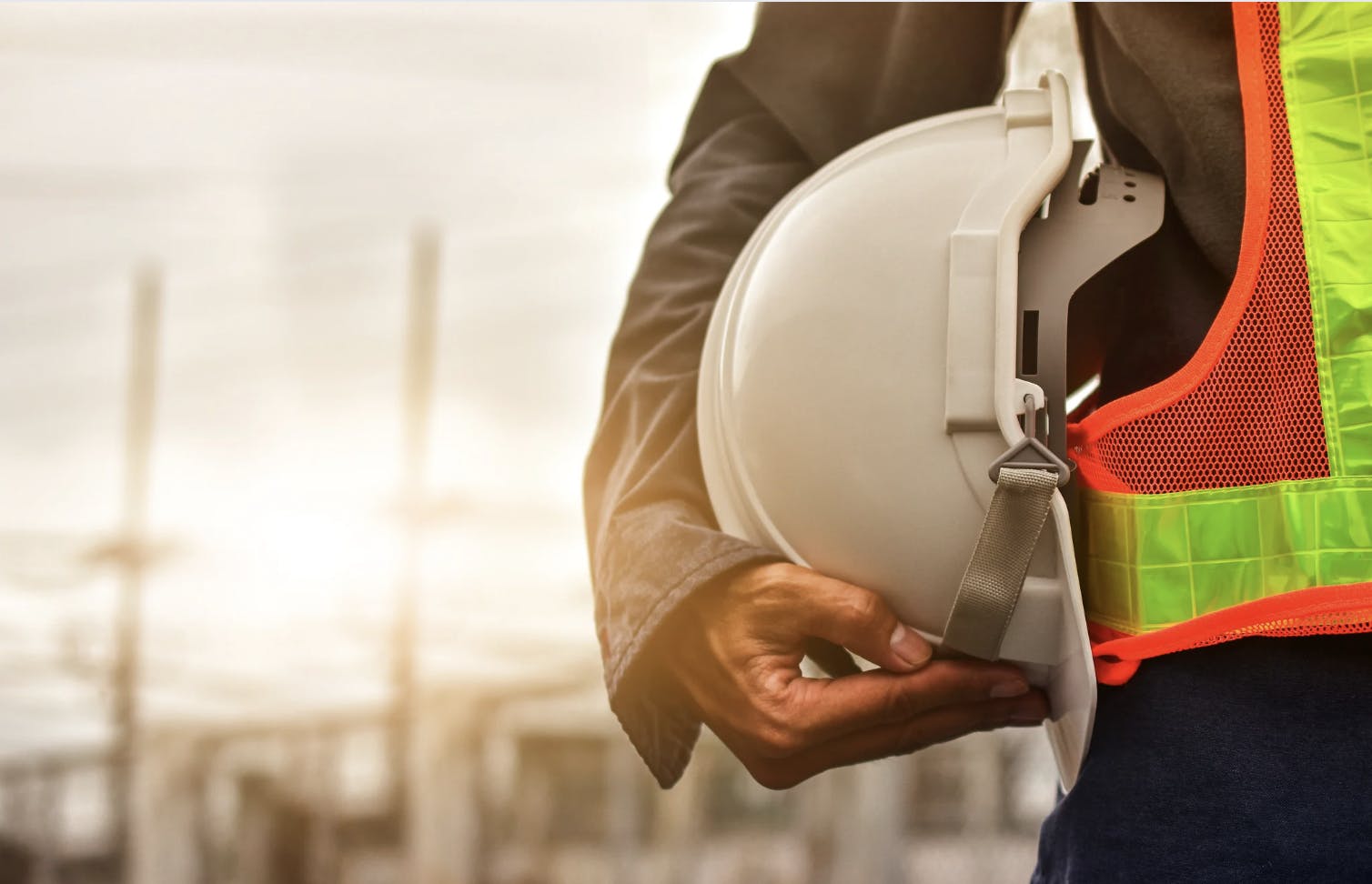 An industrial technician holds his hard hat