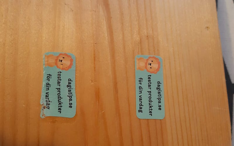 Till vänster en felaktigt monterad stryknamnlapp på träbit, till höger en korrekt monterad stryknamnlapp på träbit.