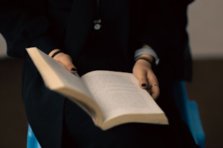 A woman holds a book open.