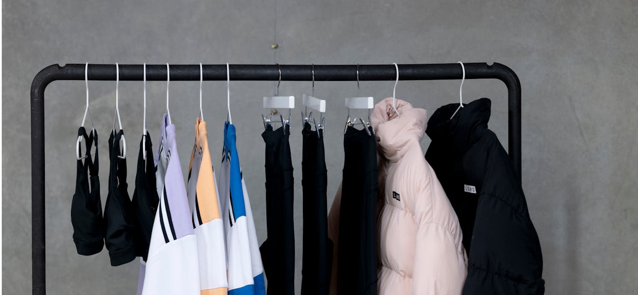 A rack of LSKD merchandise including tops, leggings, puffer jackets