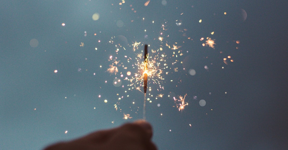 A close up of a hand holding a sparkler