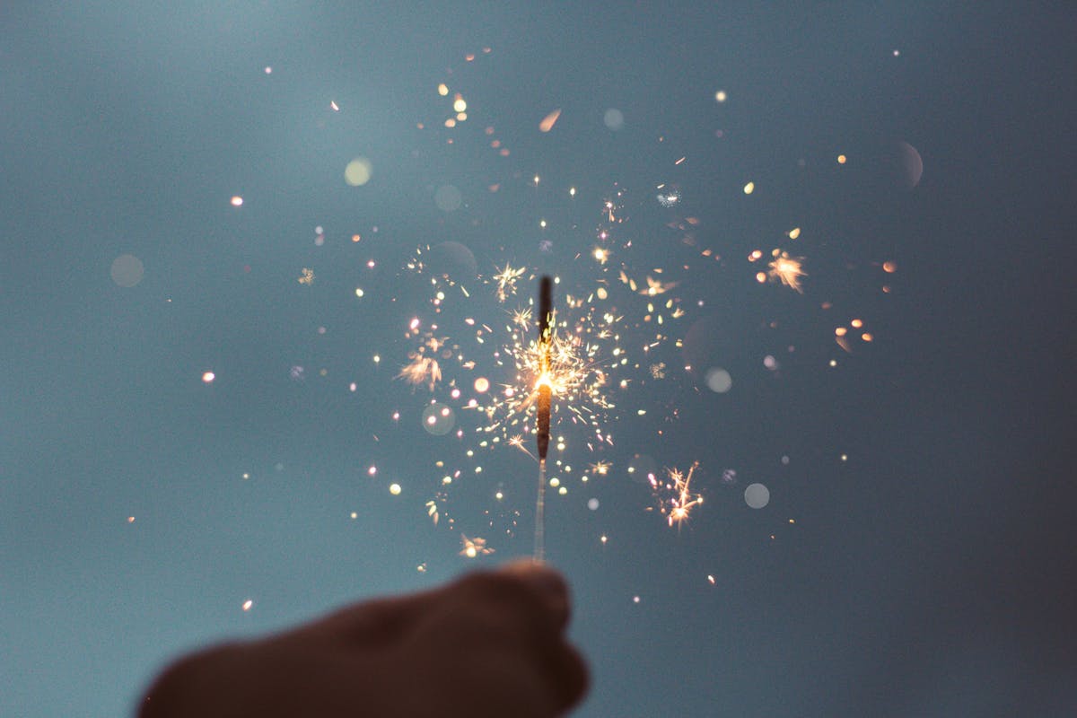 A hand holding a sparkler up close