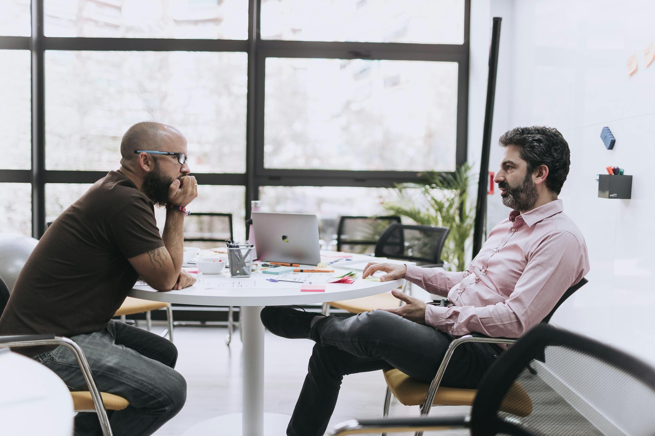 Dos personas sentadas frente a frente discutiendo la efectividad del equipo