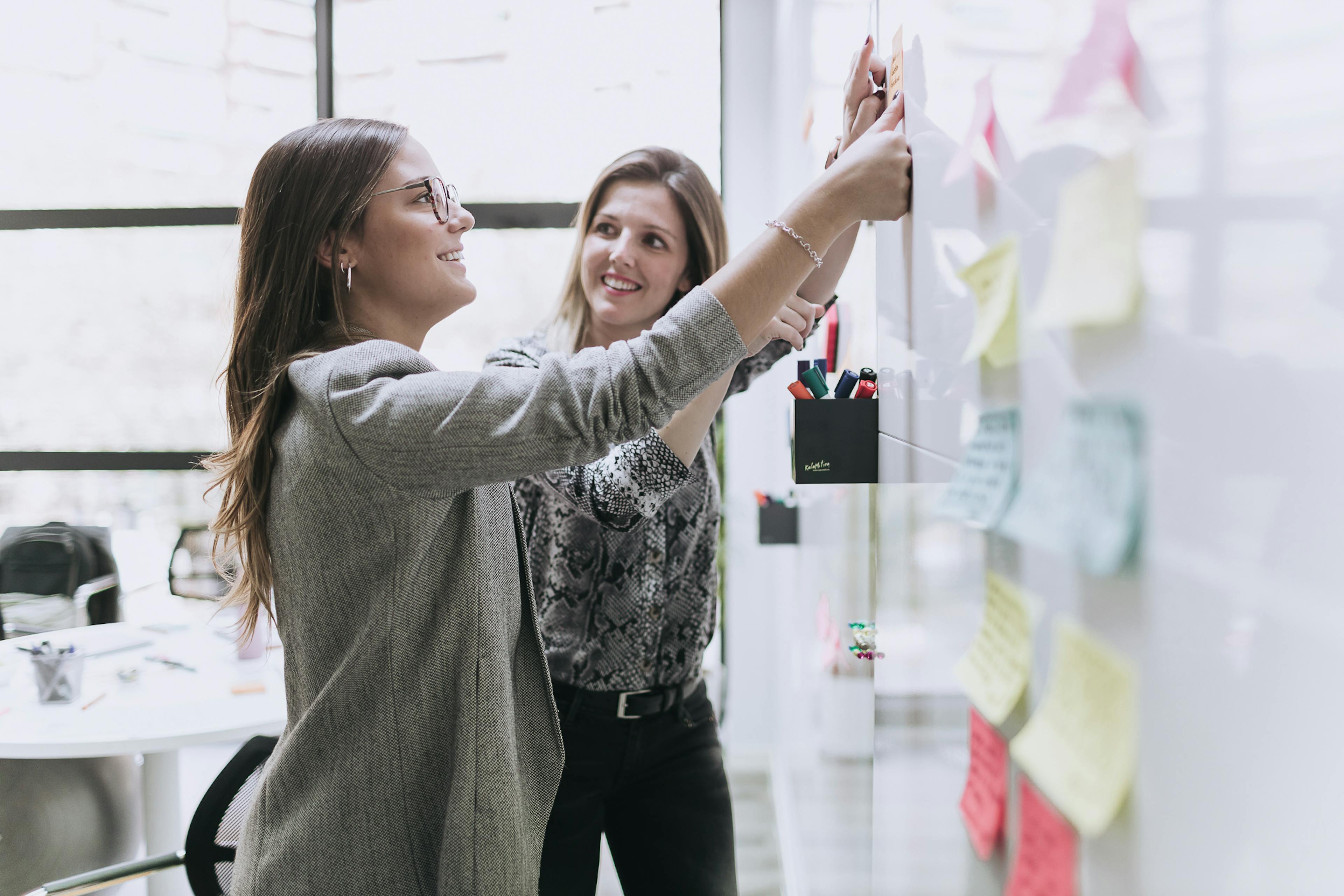 two colleagues writing post-its