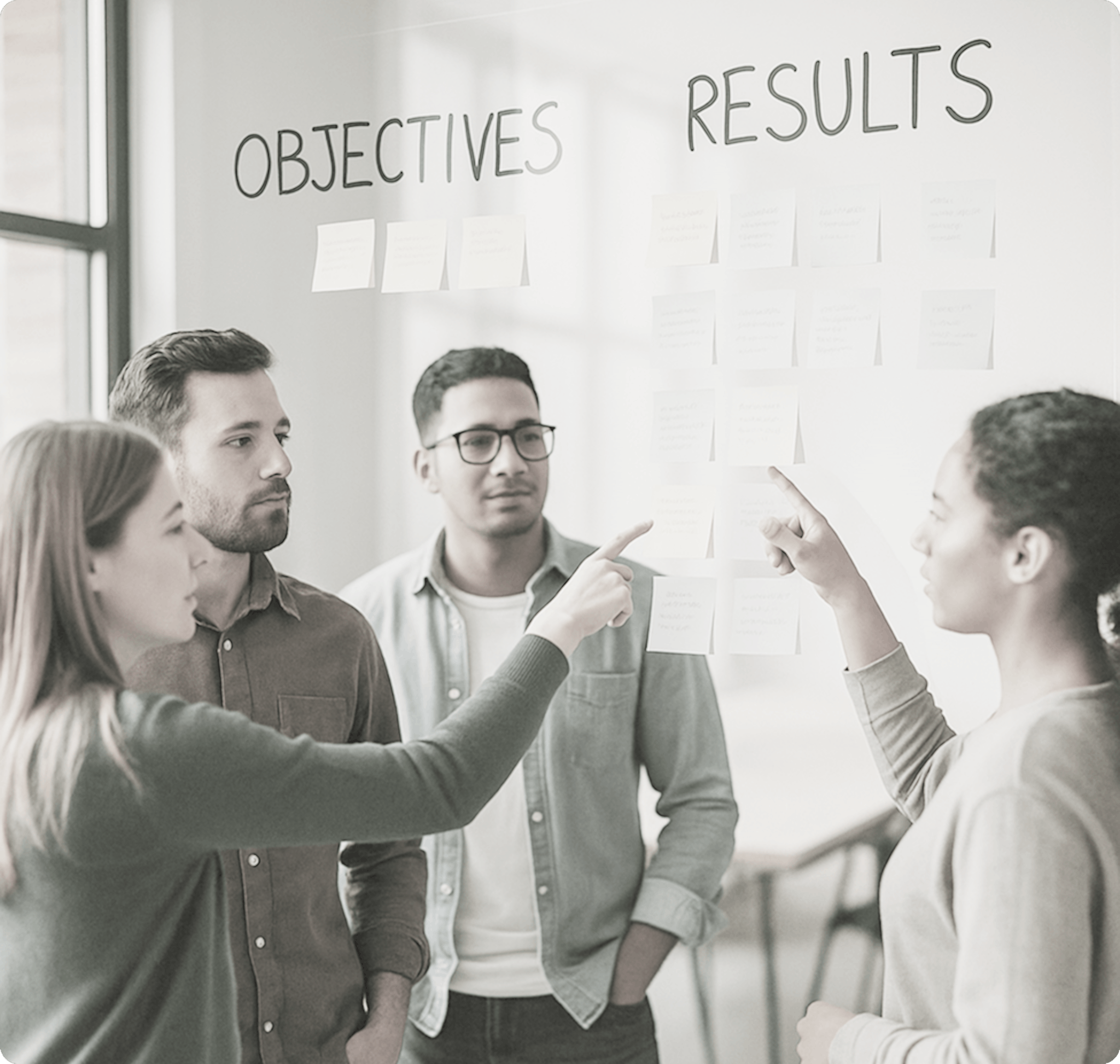 Team collaborating on OKRs with sticky notes on a glass board
