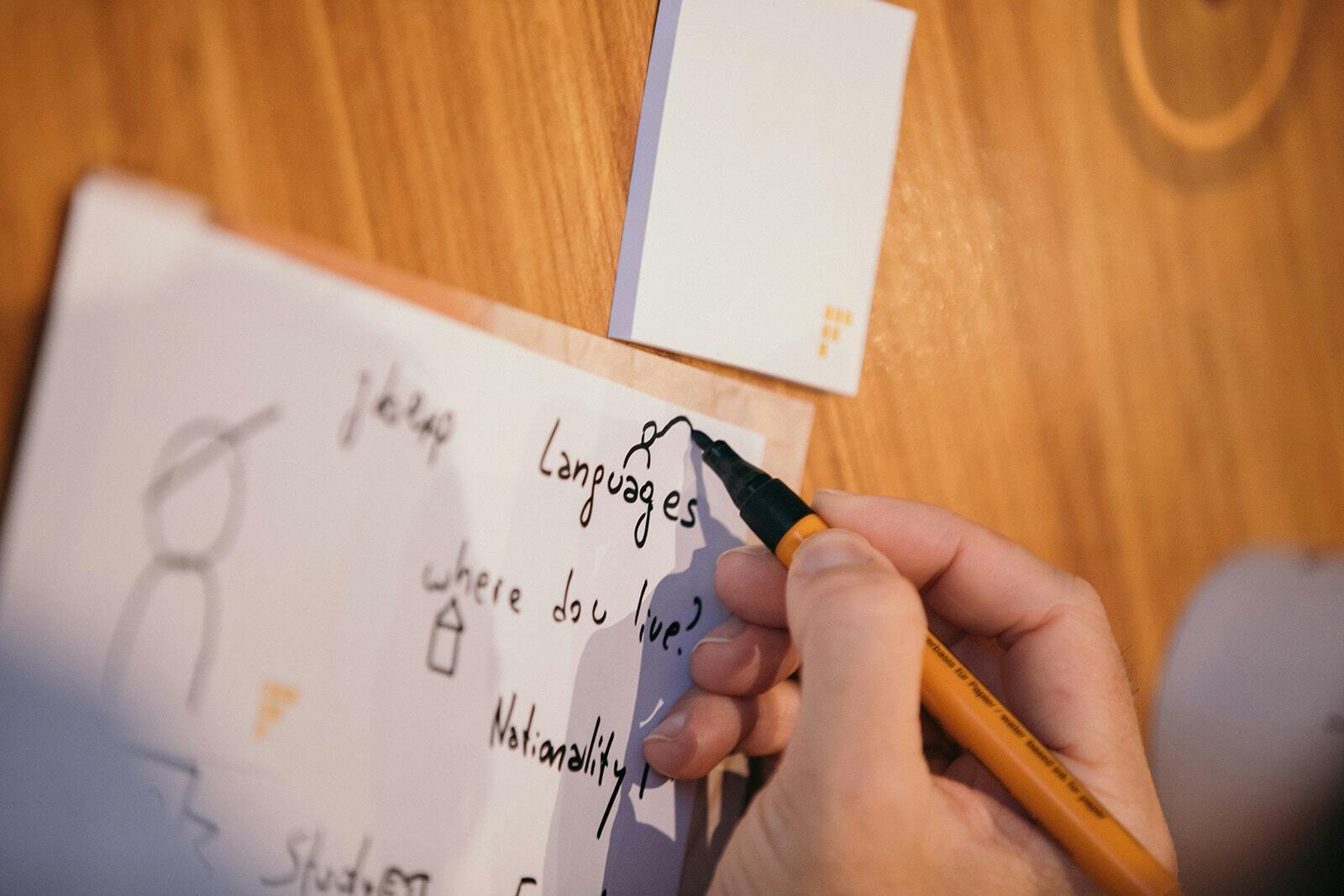 A person's hand writing a Product Goal