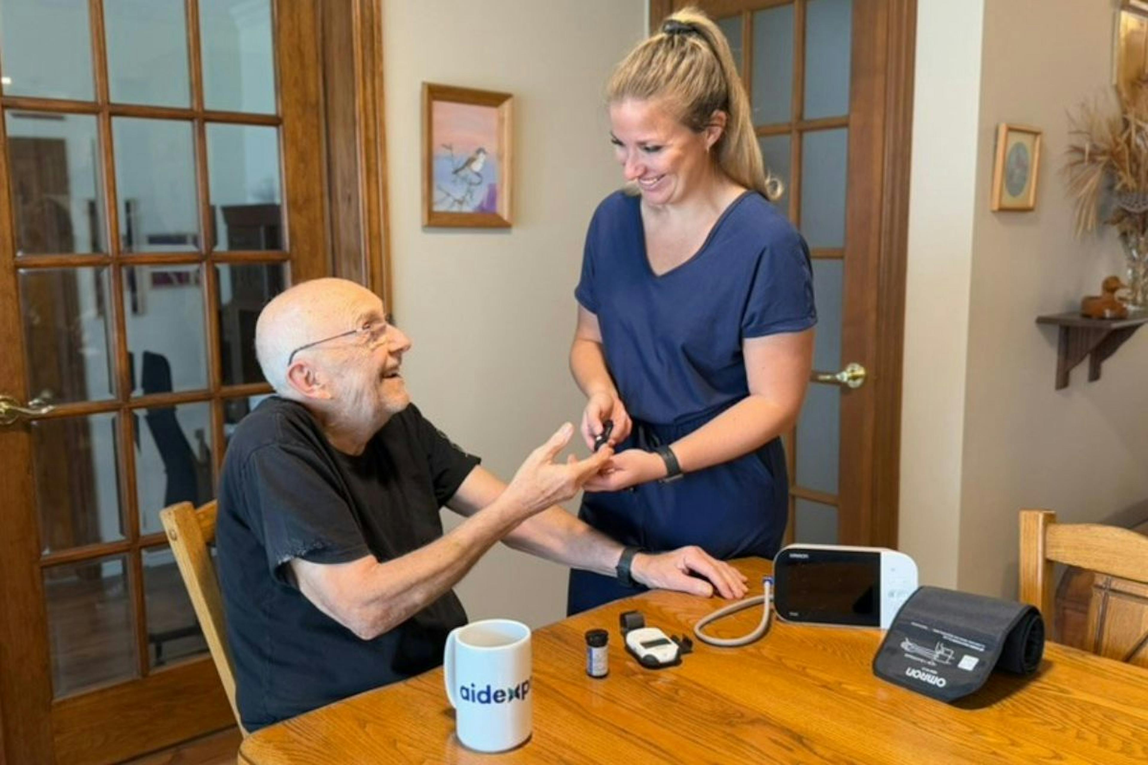 Une préposée aux bénéficiaires donne des soins à domicile à un homme âgé
