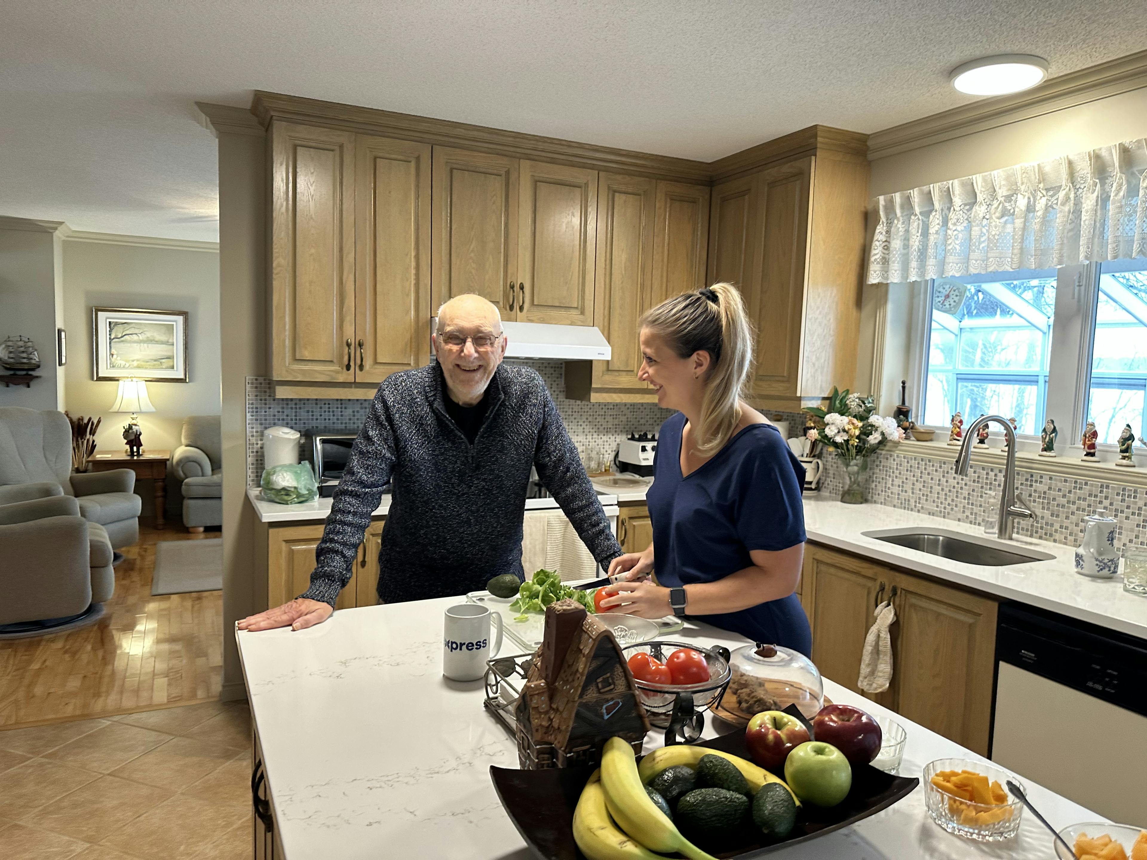 une aidante prépare le repas d'une personne âgée à domicile