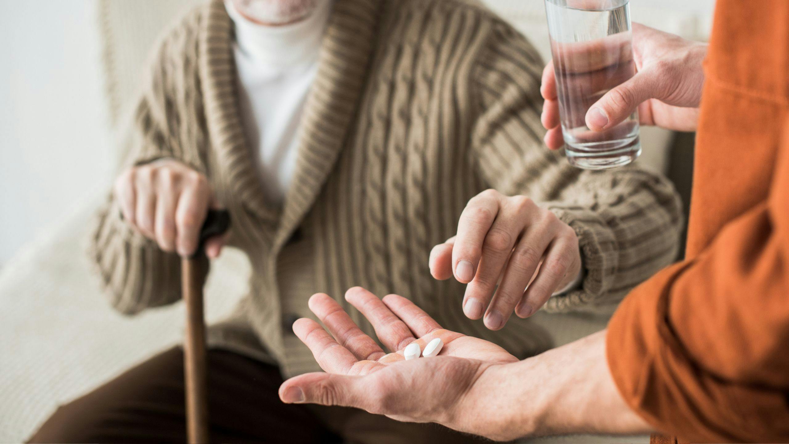 un aidant qui fait un rappel à une personne âgée que c'est le temps de prendre ses médicaments