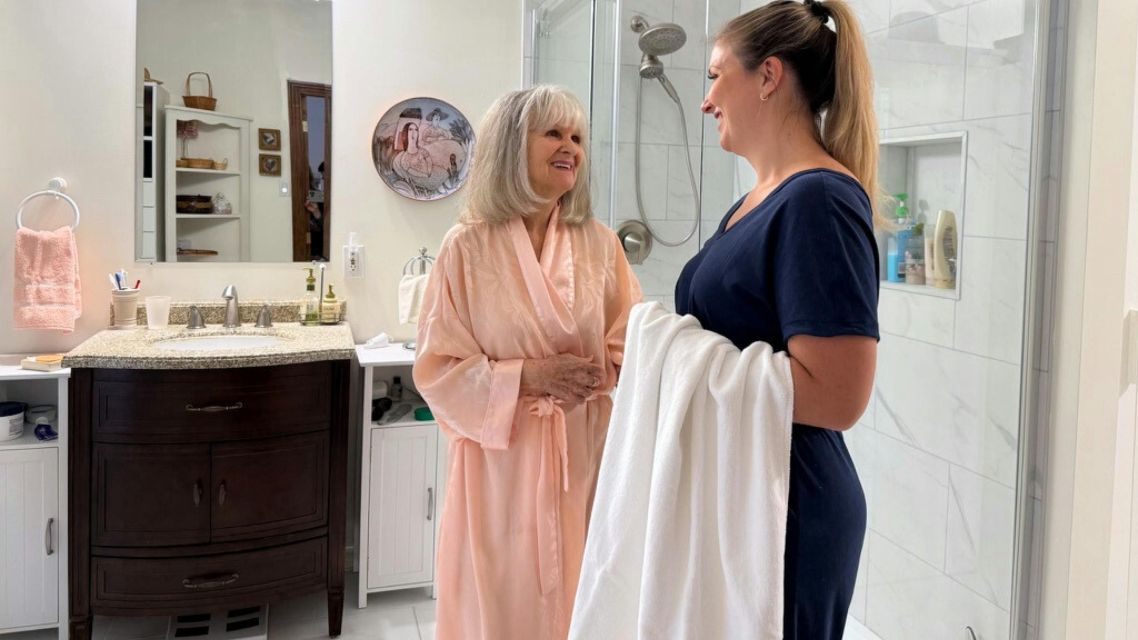 Préposée aidant une femme âgée à faire sa toilette à domicile