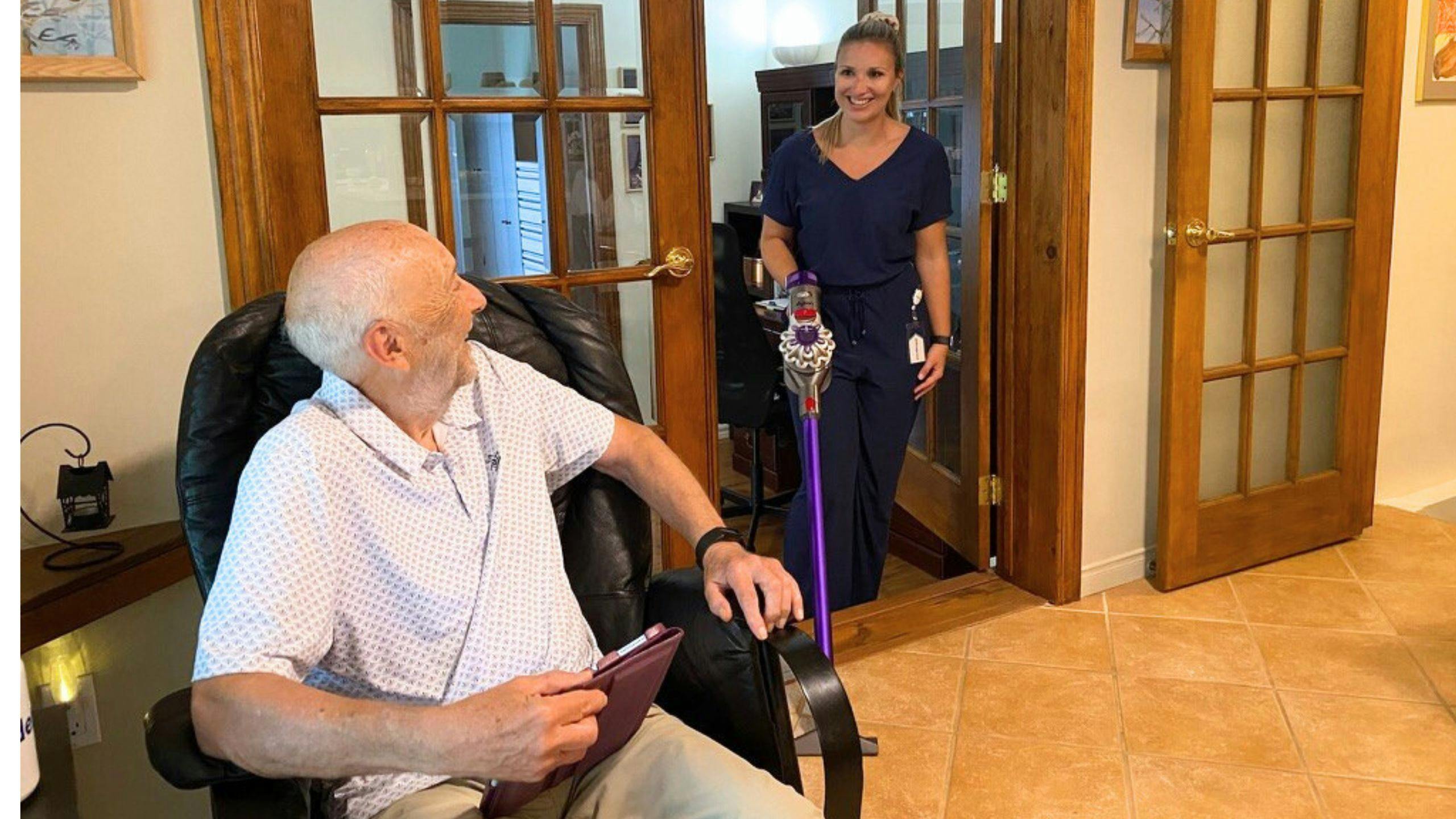 Une aidante d'Aidexpress passe l’aspirateur dans la maison d'une personne âgée