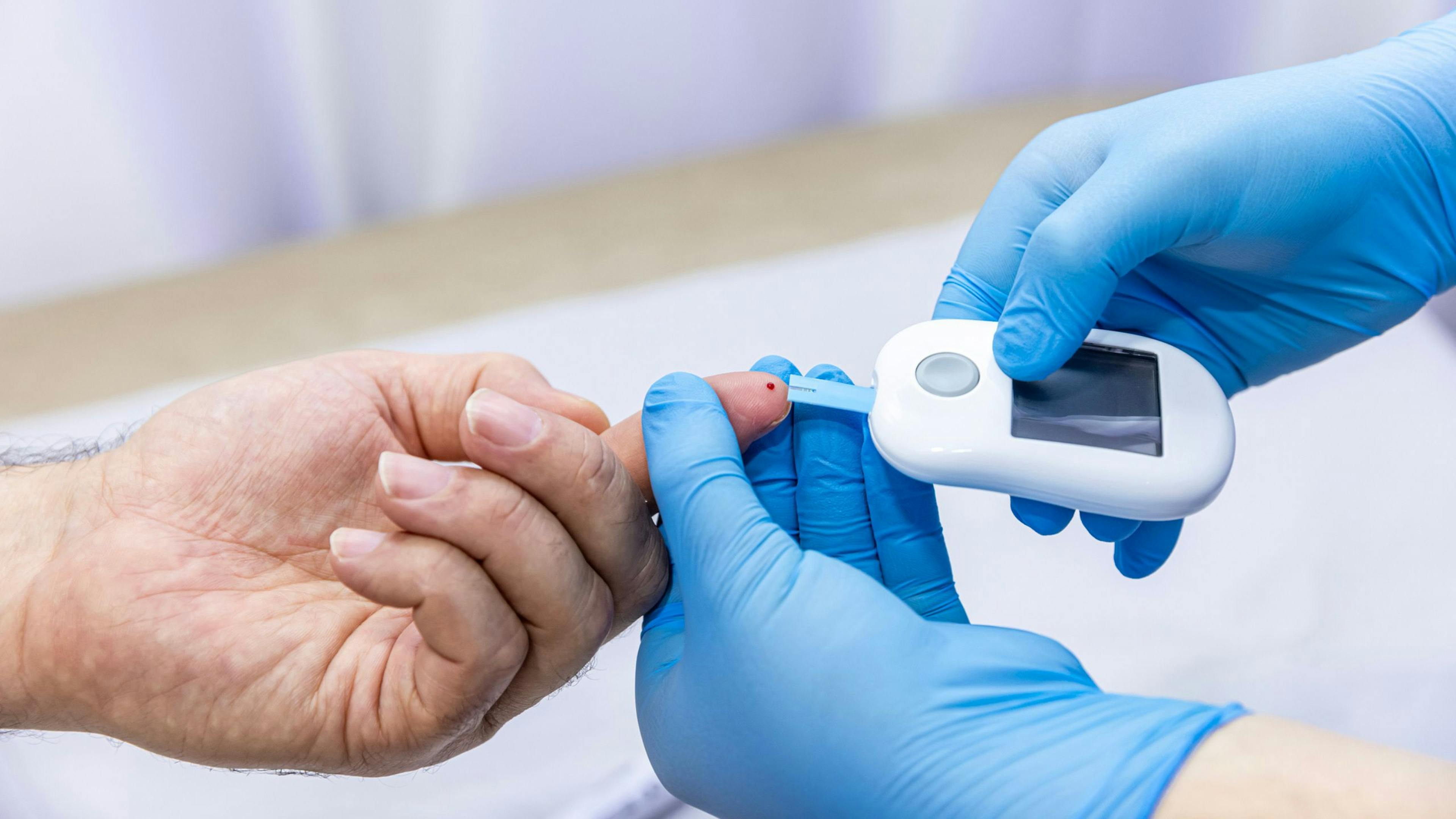 Une préposée Aidexpress en soins à domicile aide une personne âgée à mesurer sa glycémie avec un glucomètre, illustrant le suivi du diabète et l’accompagnement sécuritaire des aînés.