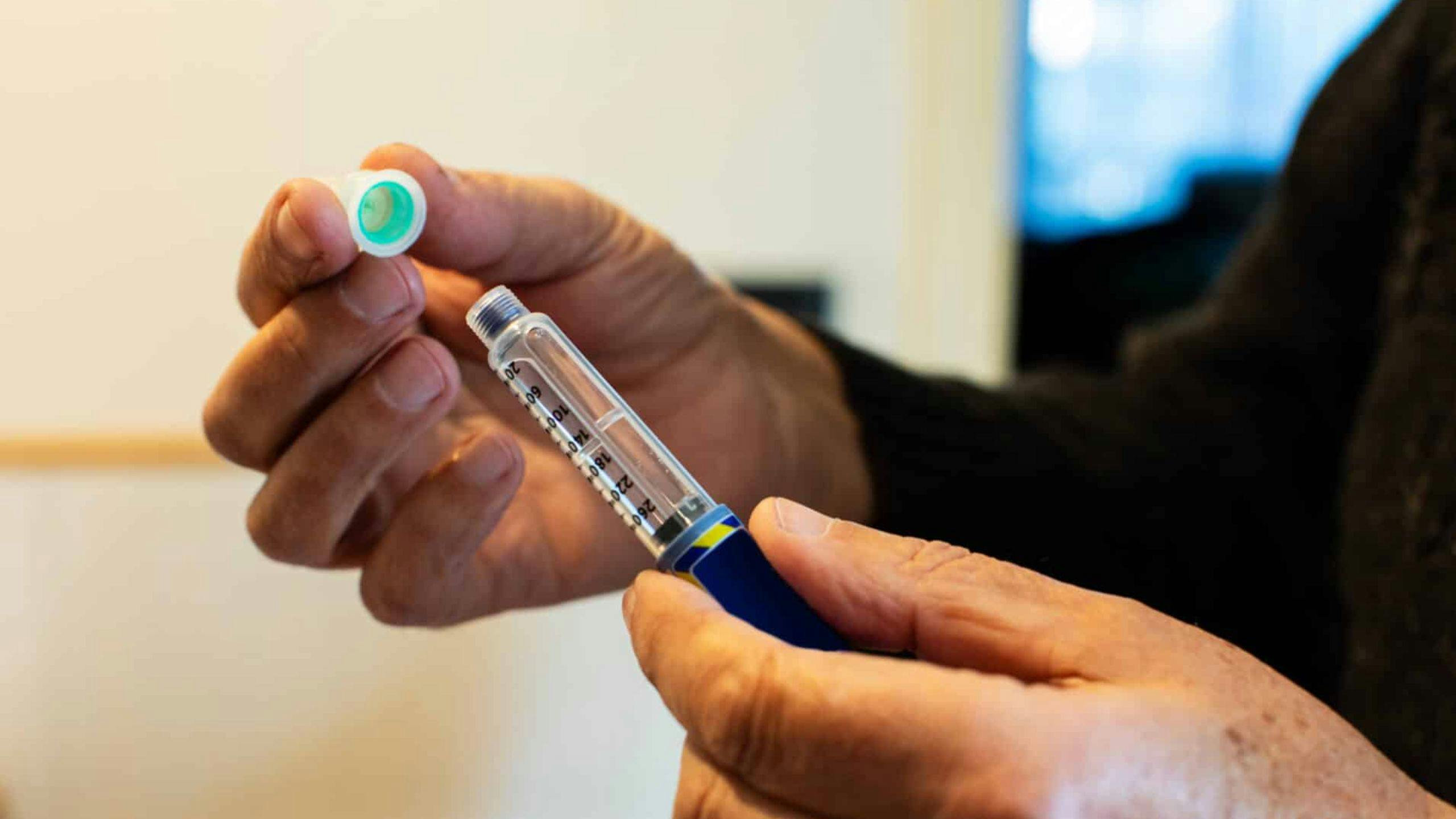 Une préposée Aidexpress en soins à domicile aide une personne âgée à s’administrer son insuline, illustrant le soutien aux aînés diabétiques et la gestion sécuritaire de la médication.