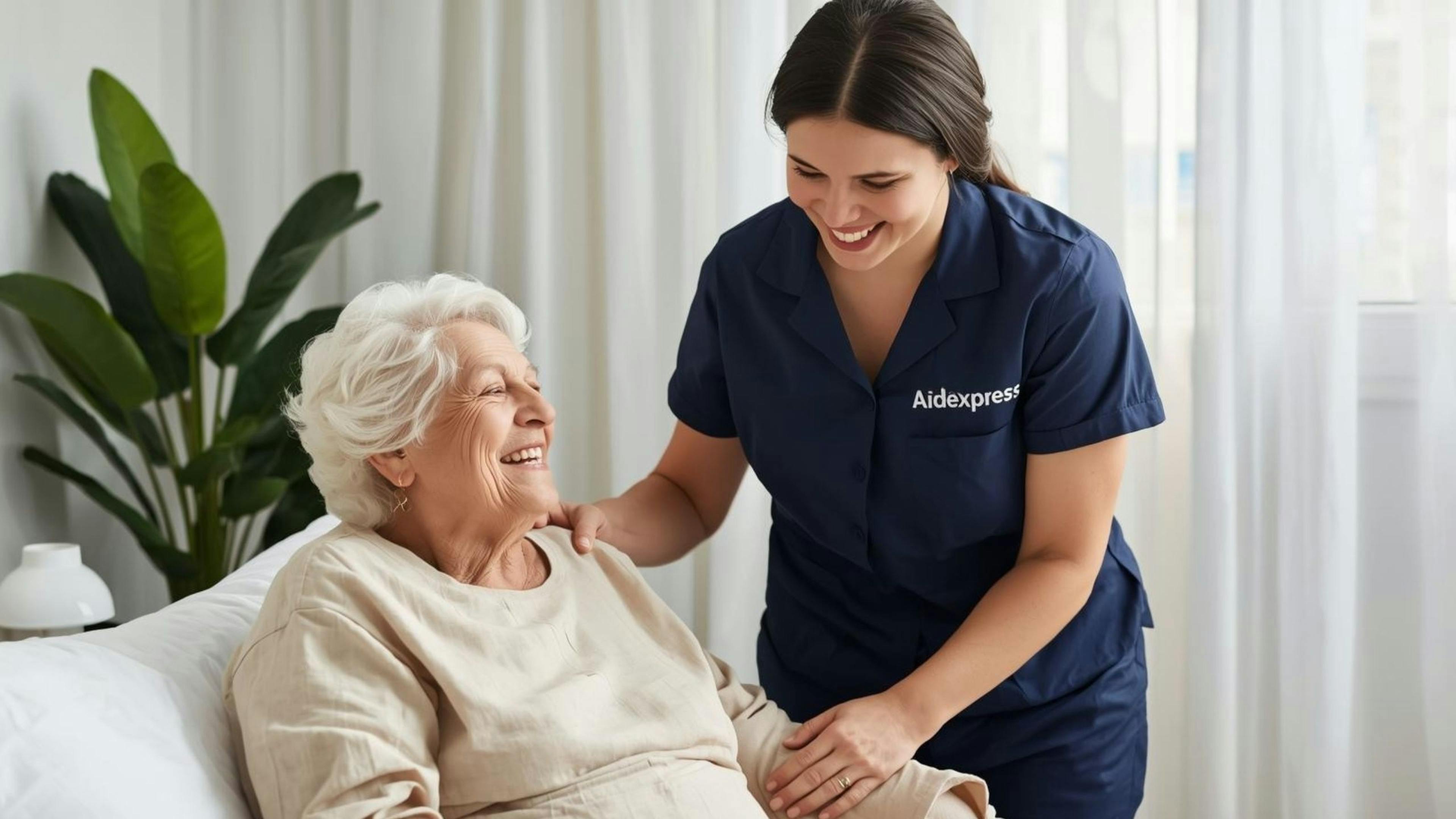 Une préposée en soins à domicile sourit et rassure une personne âgée, illustrant l’aide aux soins d’hygiène et le soutien respectueux des aînés vivant avec une stomie.