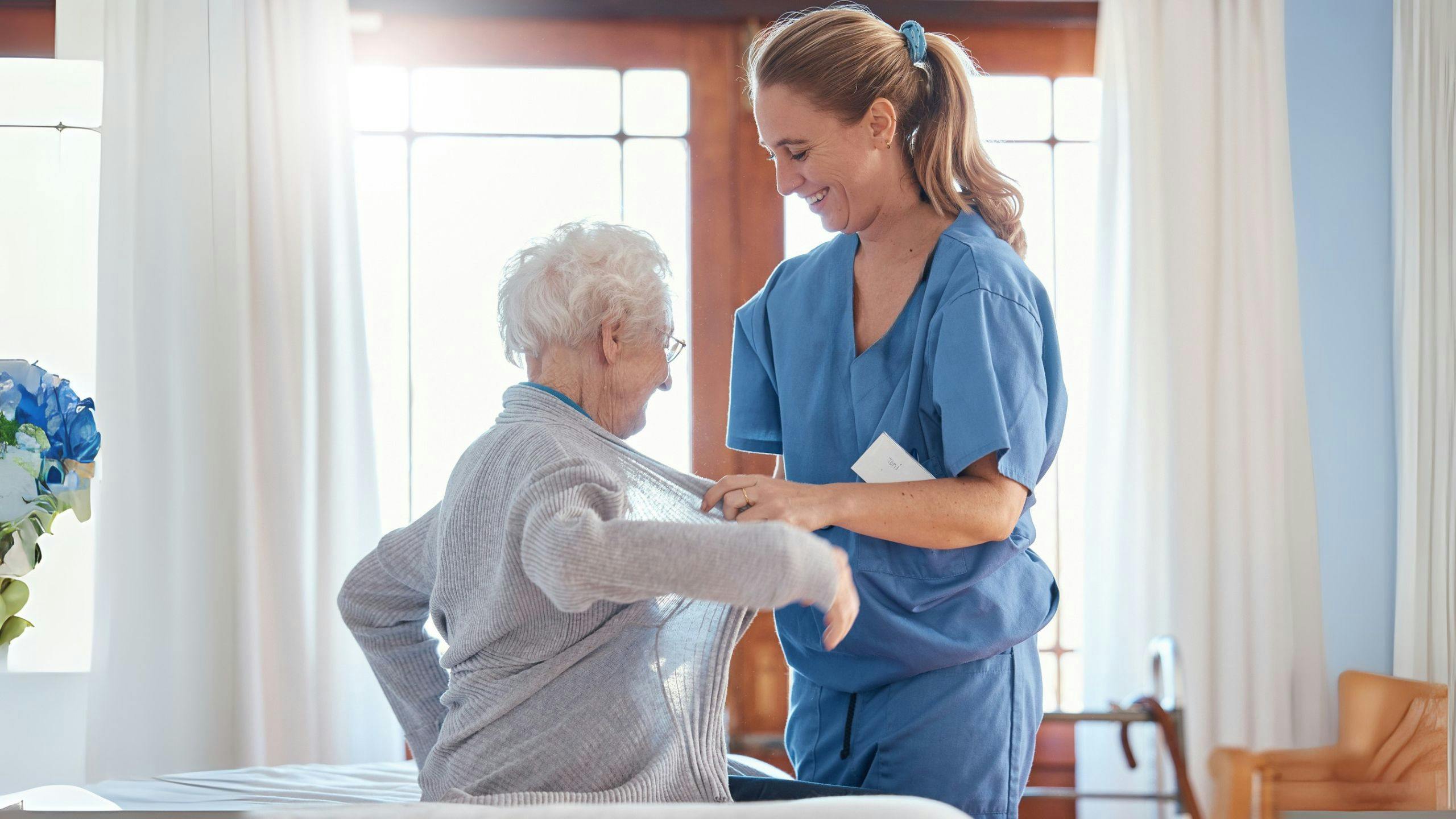 Préposée Aidexpress aidant une personne âgée à s’habiller en toute sécurité, avec respect et bienveillance.